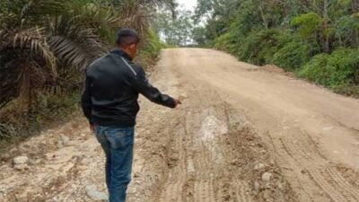 JALAN RUSAK-Warga di sekitar jalan yang rusak dan perlu diperbaiki Pemerintah Kabupaten Kuansing, dijepret baru-baru ini.