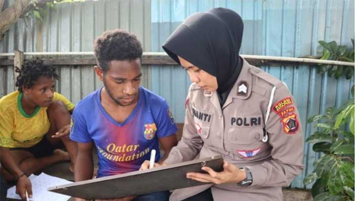 Polisi wanita ajarkan warga membaca. (ist)