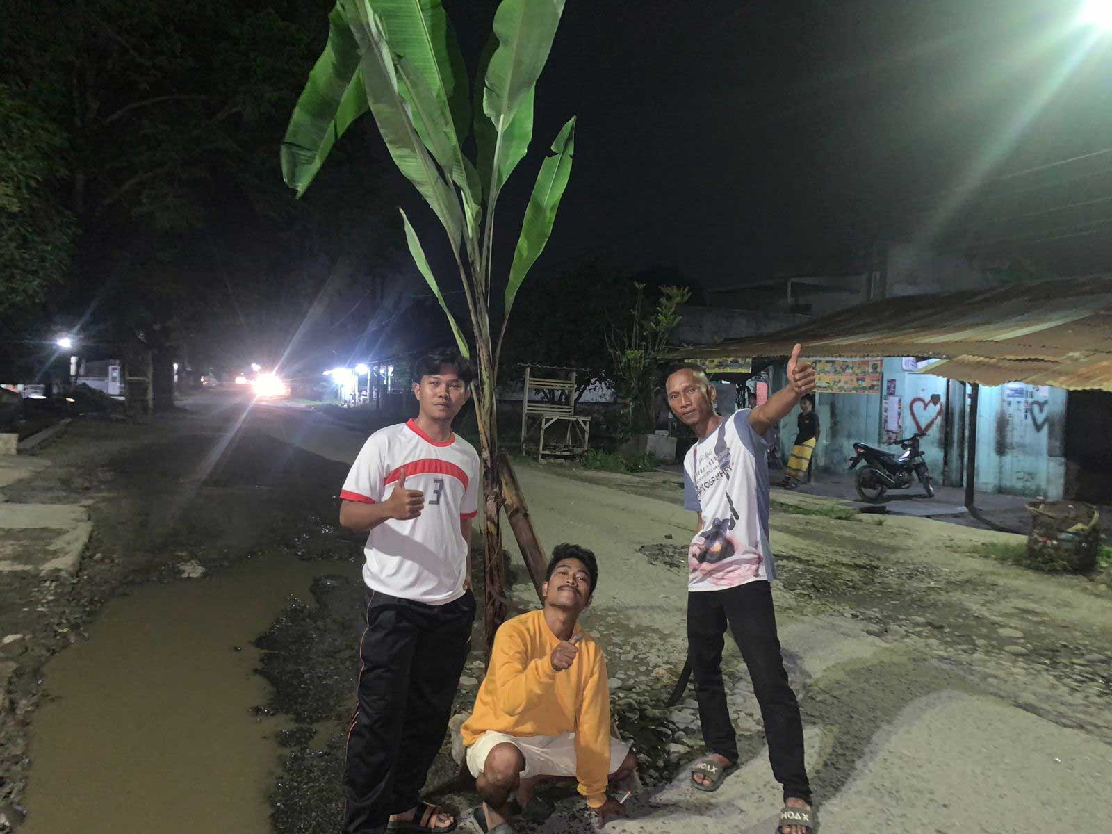 Warga Pantai Cermin tanam pisang di jalan yang rusak, Senin (6/3/2023) malam. Jalan itu berstatus jalan provinsi. (*)