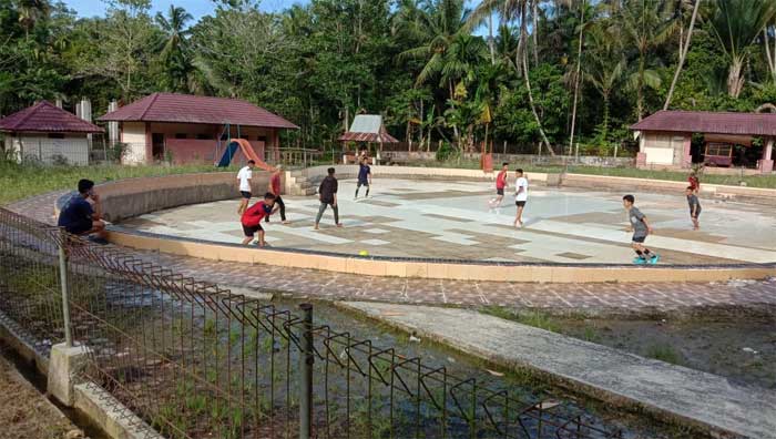 Warga main bola di kolam renang yang tak terurus