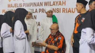 Ketua Pemuda Pancasila MPW Riau, H Arsadianto Rachman serahkan santunan pada anak yatim.