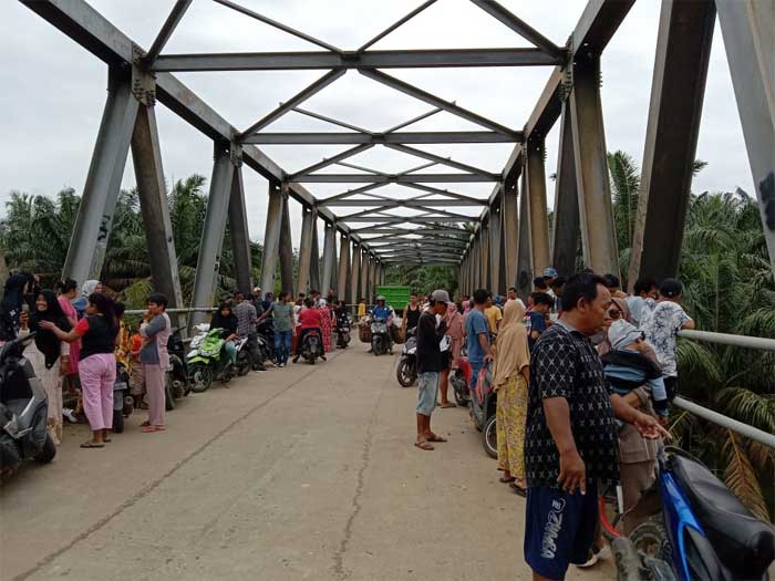 Warga berkumpul di jembatan tempat seorang ibu rumah tangga melonat ke sungai