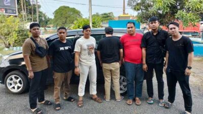 Polisi aman tersangka (membelakangi kamera) yang diduga gelapkan dana SPBU. (tribratanews.lampung.polri.go.id)