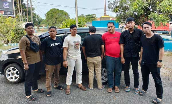 Polisi aman tersangka (membelakangi kamera) yang diduga gelapkan dana SPBU. (tribratanews.lampung.polri.go.id)
