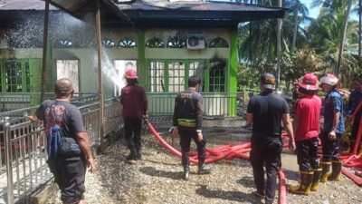 Petugas melakukan pendinginan di surau yang terbakar. (suhanews.co.id)