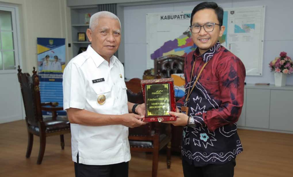 Bupati Surya serahkan plakat pada Kepala Bank Mandiri Cabang Kisaran, Dicky Kurniawan.