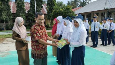 Sekretaris DPD SatuPena Sumatera Barat, Armaidi Tanjung serahkan buku sumbangan DPD SatuPena Sumatera Barat kepada perpustakaan SMPN 5 Kota Pariaman, Senin (31/7/2023).