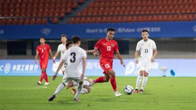 Pemain Indoesia berebut bola dengan pemain Kirgistan di Zhejiang Normal University East Stadium, Jinhua, China, Selasa (19/9/2023). (noc indonesia)