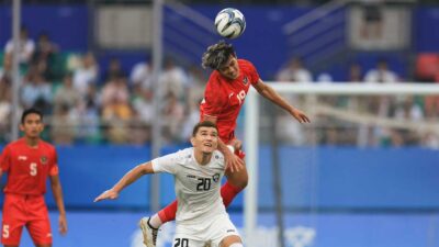Pemain Indonesia dan Uzbekistan berebut bola dalam laga 16 besar Asian Games cabang sepak bola. (noc indonesia)