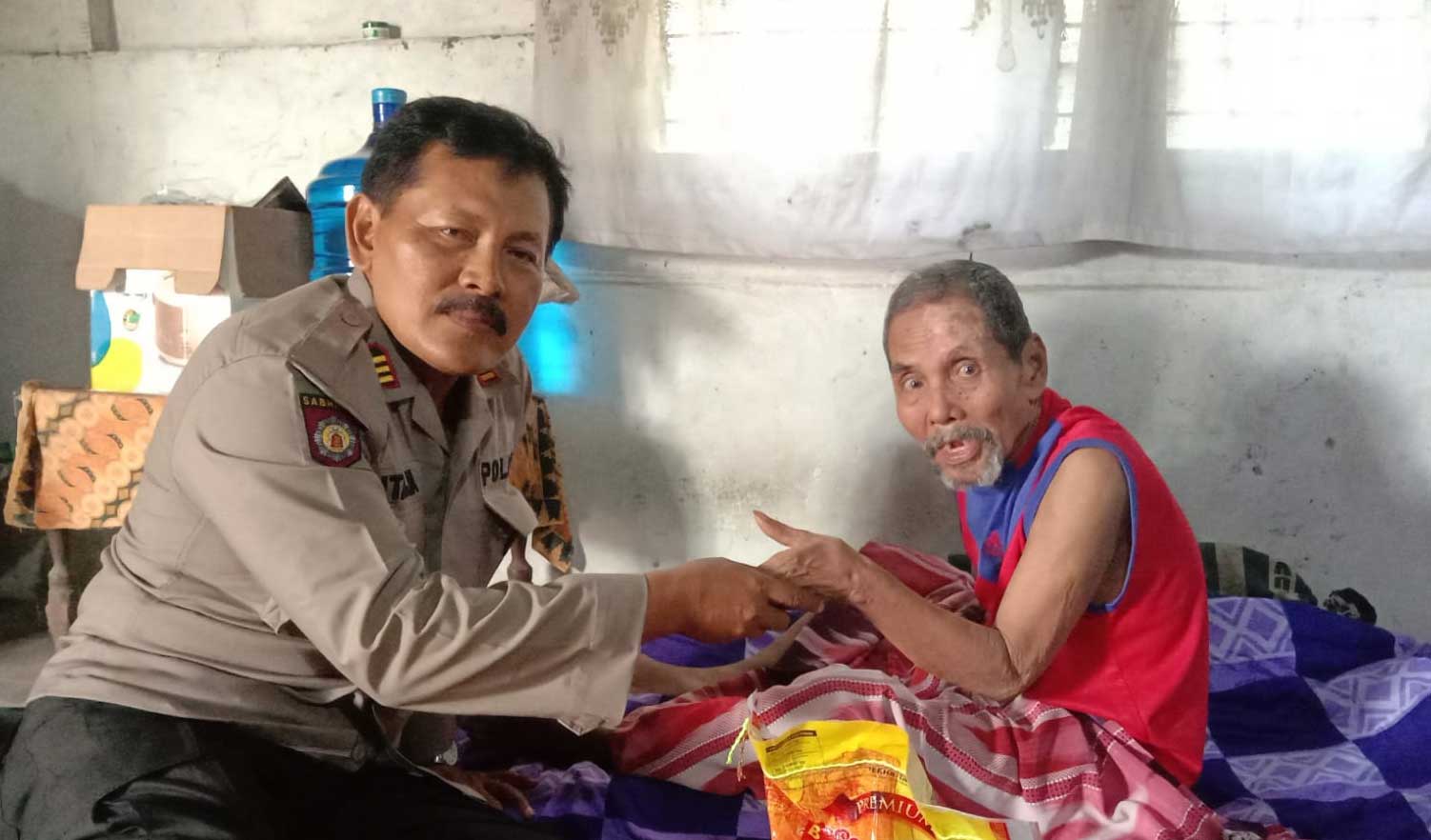 Kapolsek AKP Sutarja berikan bantuan pada penderita stroke yang berusia 60 tahun di Dusun II, RT04/RW02 Desa Koto Rajo, Kecamatan Kuantan Hilir Seberang,
