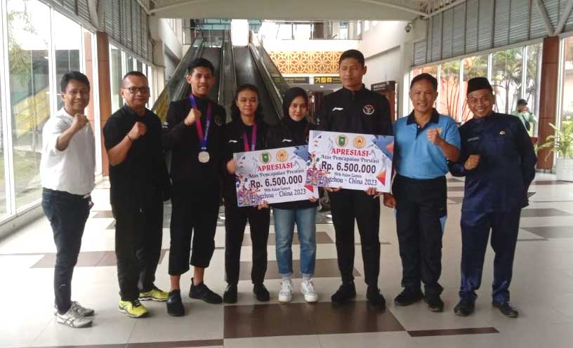 Foto bersama usai penyerahan bonus di bandara. (riau.go.id)