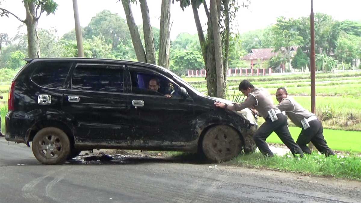 Petugas evakuasi mobil yang mengalami kecelakaan tunggal di jalan lintas Sumatera.