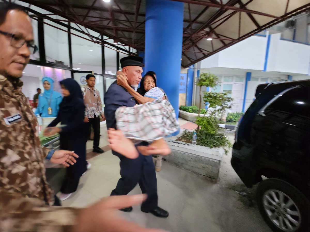 Gubernur Mahyeldi gendong ibu di rumah sakit saat hendak dibawa pulang setelah dinyatakan sembuh. (pemprov)