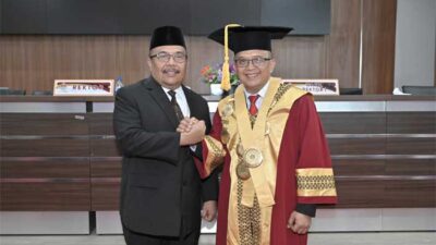 Sekdaprov Hansastri bersama salah seorang guru besar yang dikukuhkan. (pemprov)