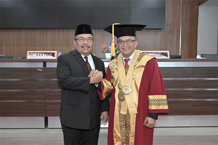 Sekdaprov Hansastri bersama salah seorang guru besar yang dikukuhkan. (pemprov)