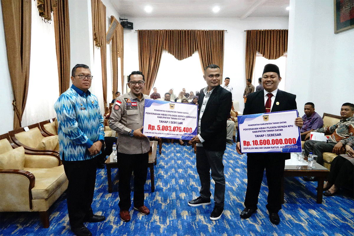 Bupati Eka Putra serahkan dana hibah kepada Ketua KPU Tanah Datar Dicky Andrika dan Ketua Bawaslu Tanah Datar Andre Azki, Kamis (28/12/2023) di gedung Indojolito Batusangkar. (prokopim)