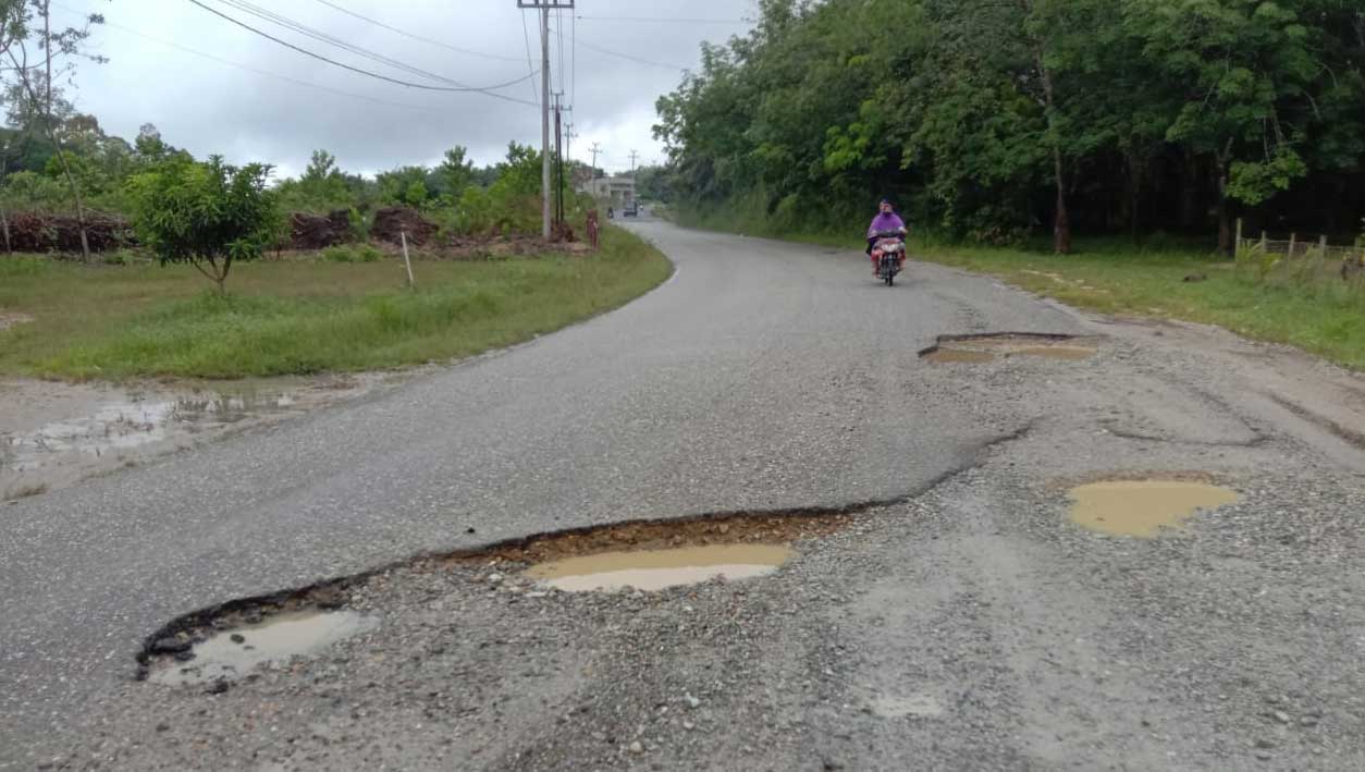 Jalan berlubang di Jalan Genting Desa Muaro Sintajo, Kecamatan Sintajo Raya, Kabupaten Kuansing, Riau.