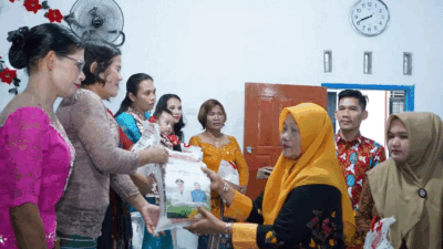 Ketua Tim Penggerak PKK Labuhanbatu Selatan, Hj. Darni Edimin serahkan bantuan pada warga, Kamis (21/12/2023).