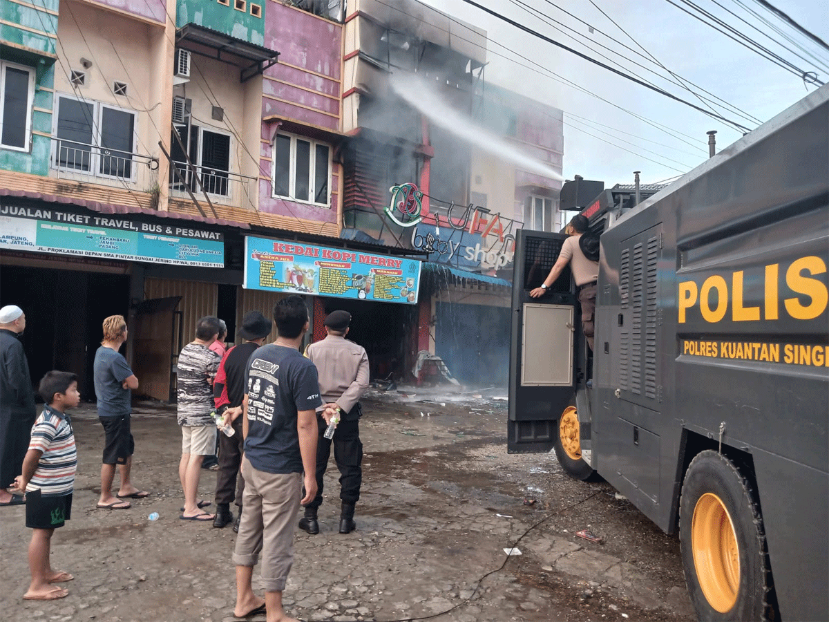 Mobil water cannon milik Polres Kuansing padamkan api di lokasi kebakaran.