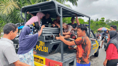 Kapolsek Pangean Bersama Anggota Evakuasi Warga yang Sakit Saat Banjir