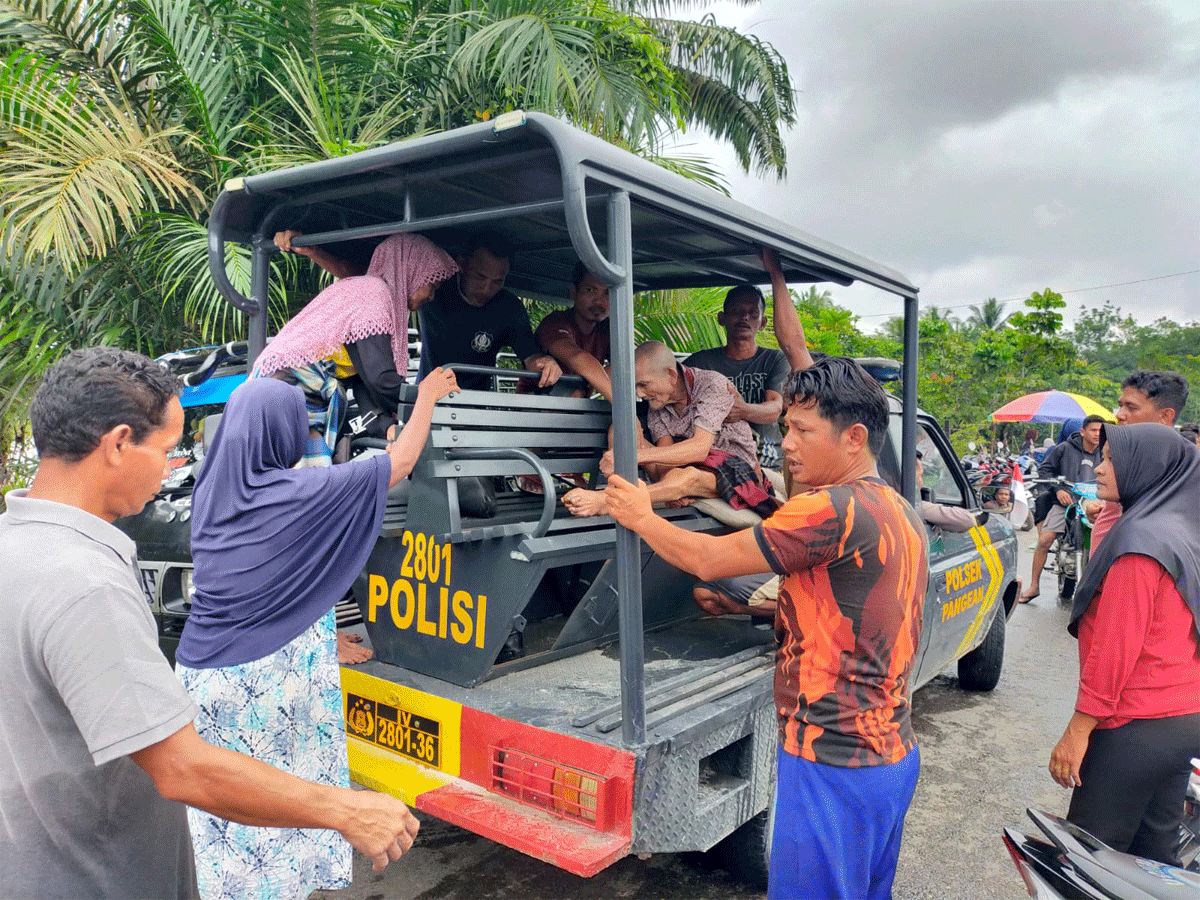 Personel kepolisian evakuasi warga yang terdampak banjir.