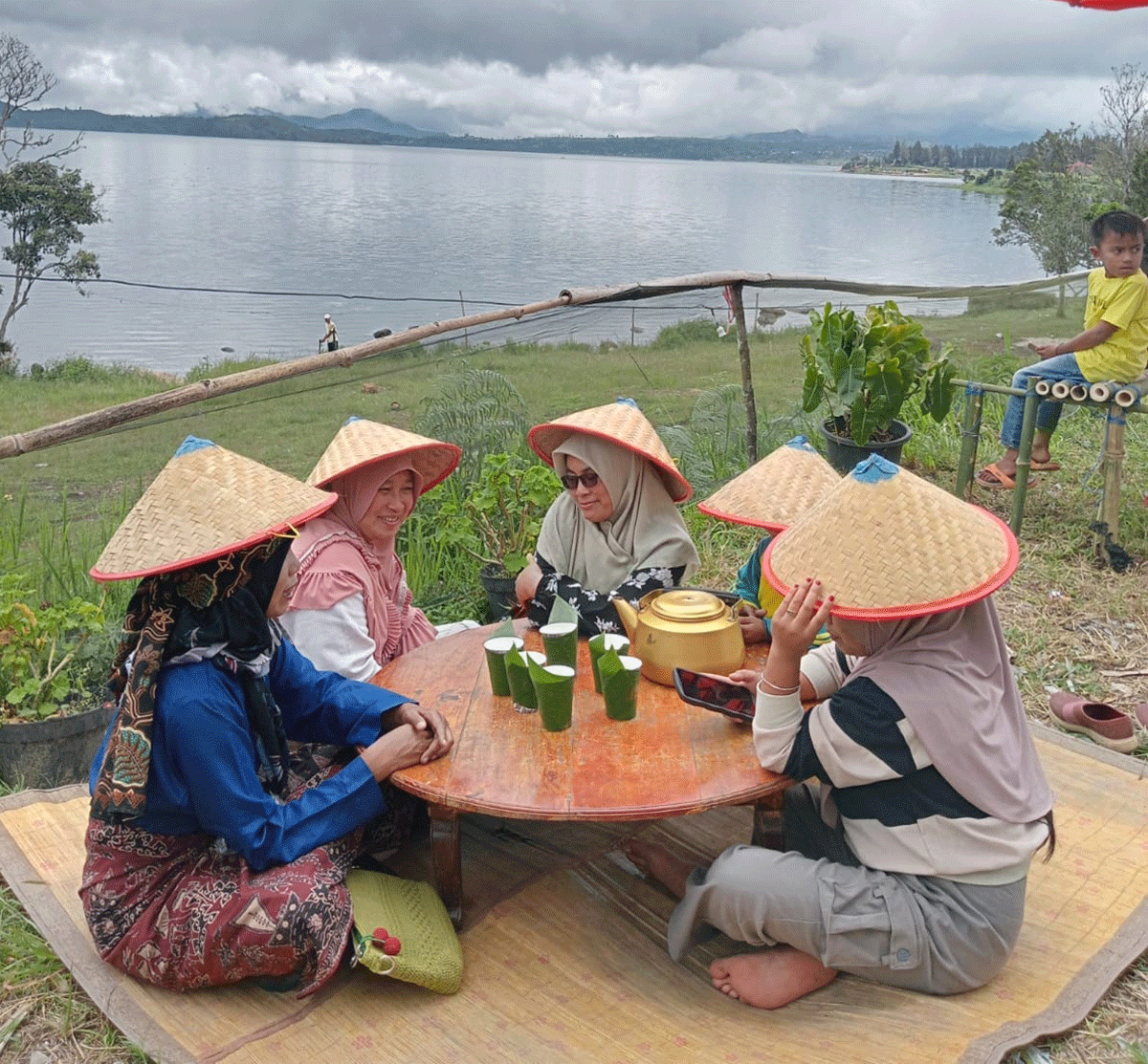 Wisatawan menikmati panorama danau sambil makan siang