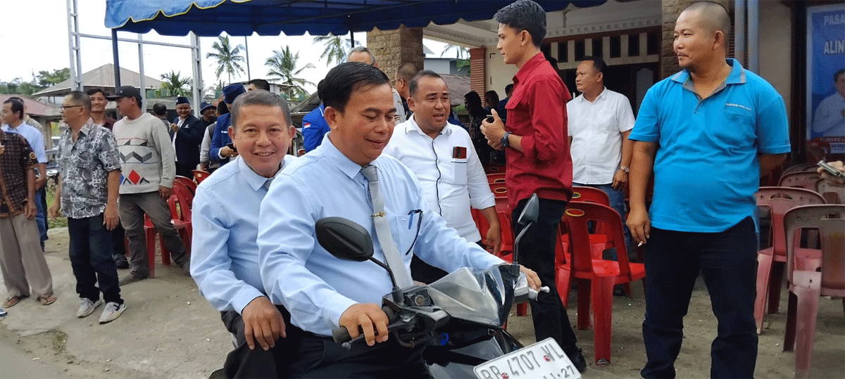 Alinuru Laoli bonceng pasangannya Faozanolo Zai dengan menggunakan sepeda motor Beat menuju KPU Kabupaten Nias, Kamis (29/8/2024).