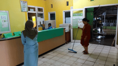 Petugas bersih-bersih setelah air masuk ke rumah sakit.