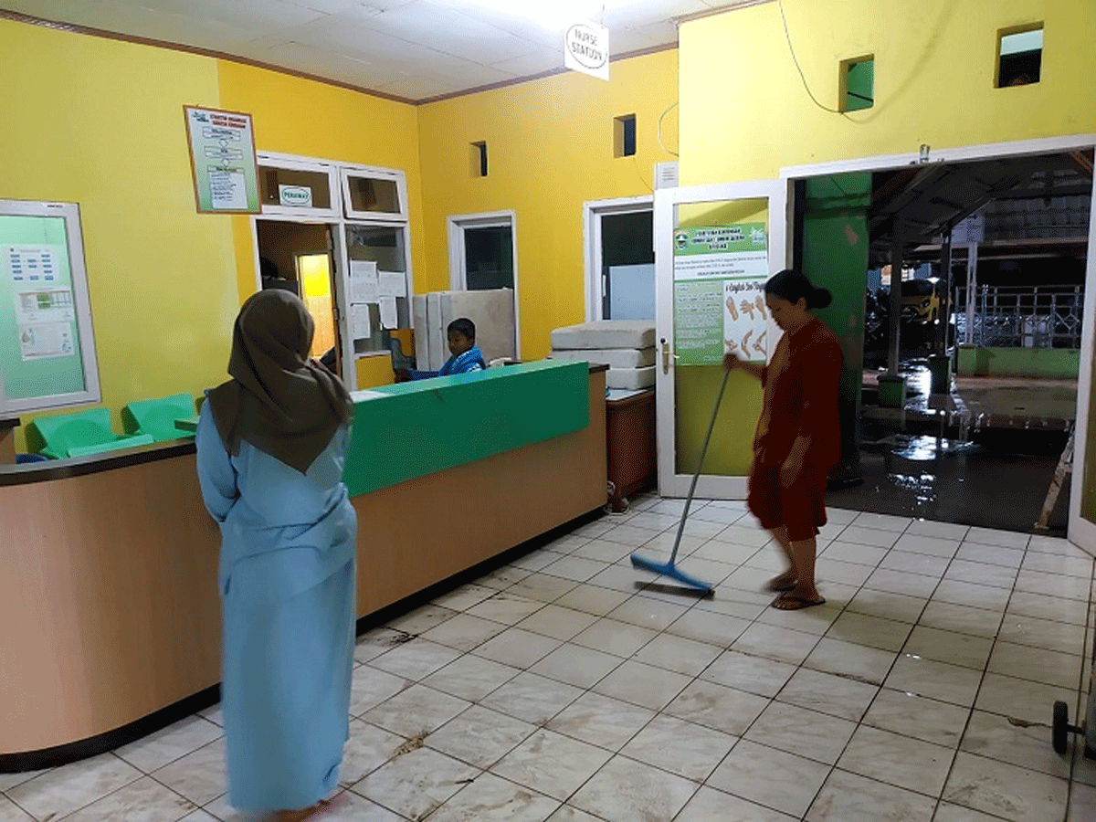 Petugas bersih-bersih setelah air masuk ke rumah sakit.