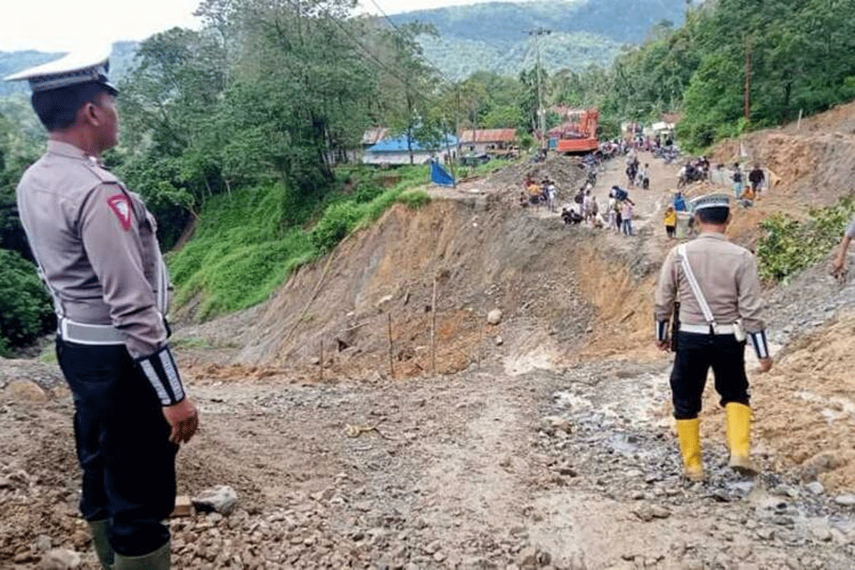 Petugas Satlantas Polres Tapanuli Selatan pantau kondisi jalan nasional Batu Jomba, yang putus total akibat longsor di Desa Luat Lombang, Kecamatan Sipirok, Tapsel, Jumat (11/10/2024). (POLRES TAPANULI SELATAN)