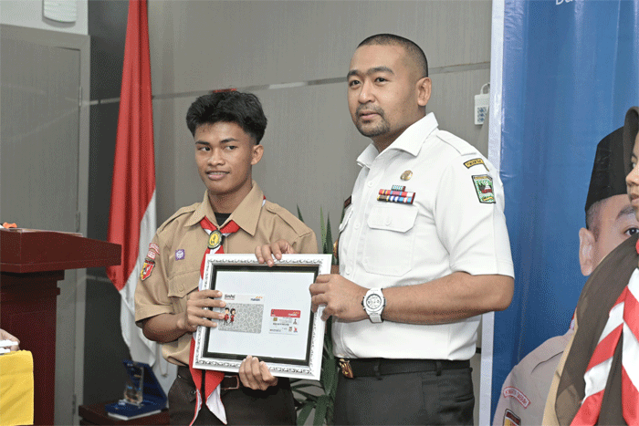 Pelaksana Tugas (Plt) Gubernur Sumatera Barat yang juga Ketua Kwarda 03 Sumbar, Audy Joinaldy serahkan kartu tanda anggota (KTA) untuk pramuka di SMK Negeri 9 Padang, Rabu (20/11/2024).