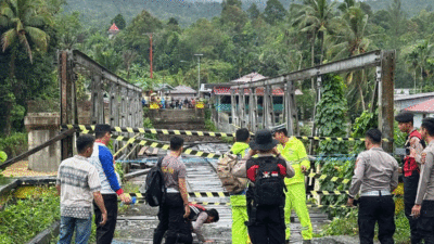 Petugas memasang police line di Jembatan Noyo di Kecamatan Mandrehe, Kabupaten Nias Barat, Sumatera Utara, Rabu (5/3/2025). Jembatan itu roboh karena diterjang banjir. (Polres Nias)