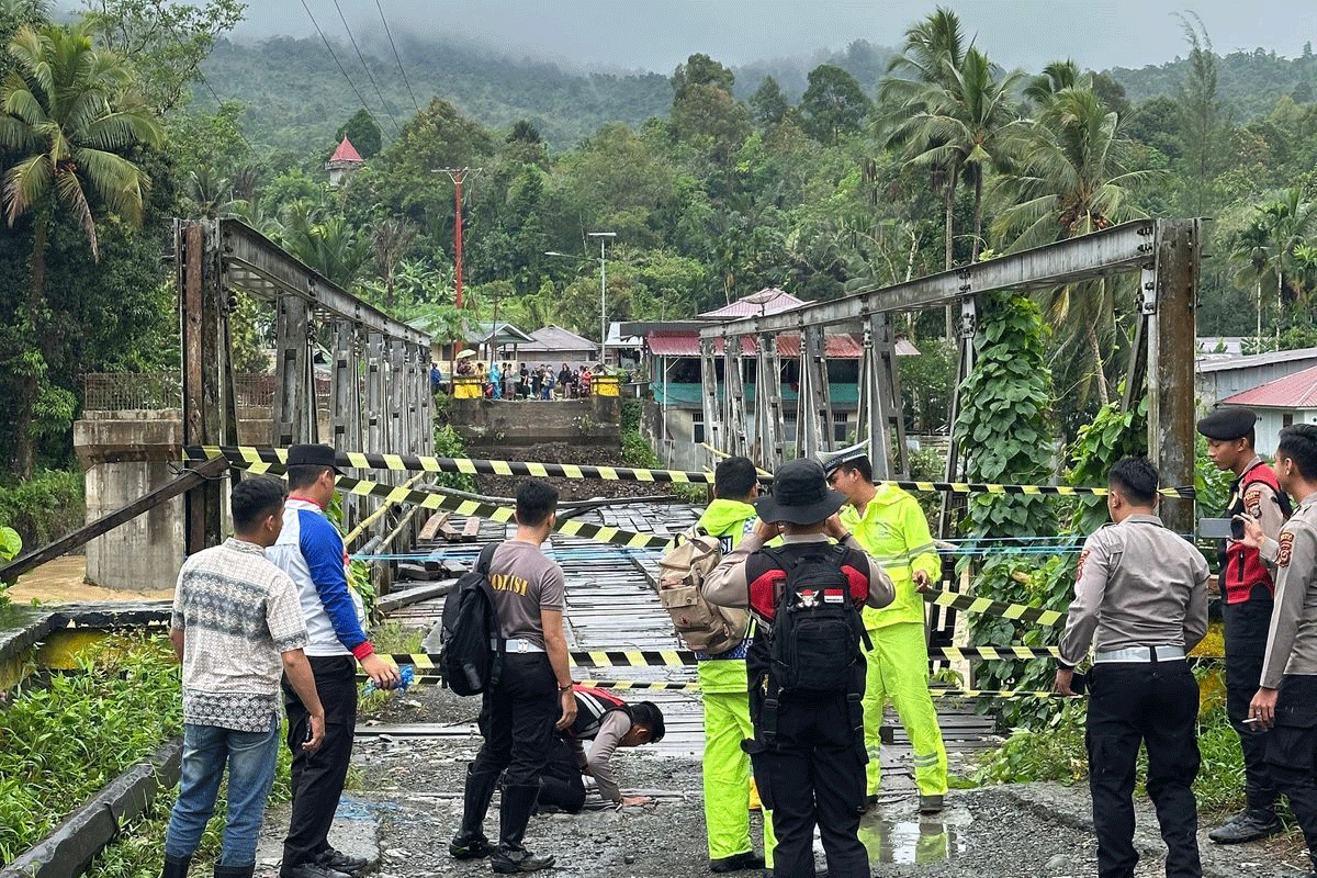 Petugas memasang police line di Jembatan Noyo di Kecamatan Mandrehe, Kabupaten Nias Barat, Sumatera Utara, Rabu (5/3/2025). Jembatan itu roboh karena diterjang banjir. (Polres Nias)