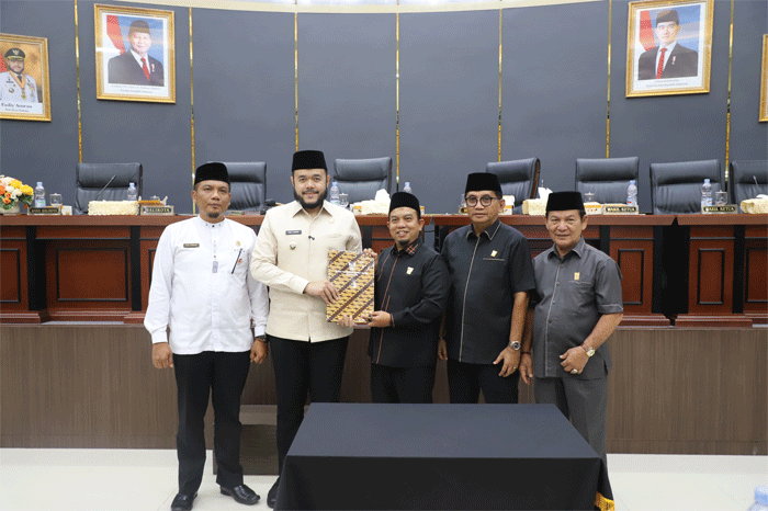 Ketua DPRD, Muharlion bersama wakil serahkan persetujuan Ranperda menjadi Perda pada Wali Kota Padang, Fadly Amran.