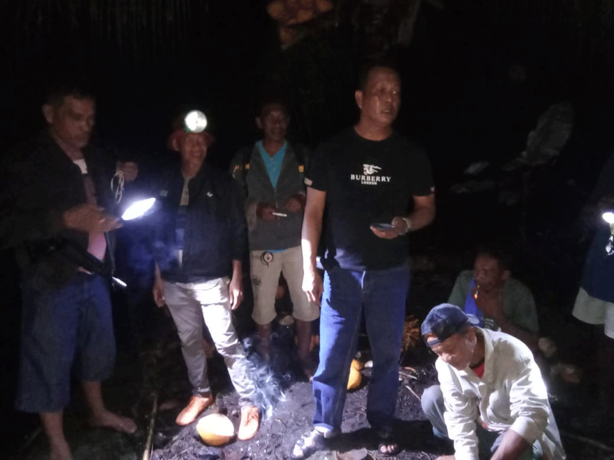 Petugas kepolisian bersama warga di lokasi kejadian.