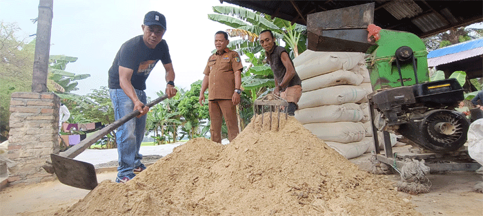 Zaini bersama Kades Naga Kisar Ahmad dan pekerjanya mengaduk pakan ternak yang sudah diolah menggunakan sisa ikan tilapia RSI, Selasa (29/7/2025)