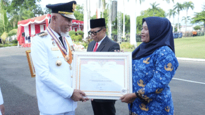 Gubernur Mahyeldi serahkan penghargaan untuk Bidan Dona. (Biro Adpim)