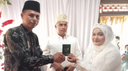 Penyerahan buku nikah kepada pengantin.