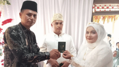 Penyerahan buku nikah kepada pengantin.