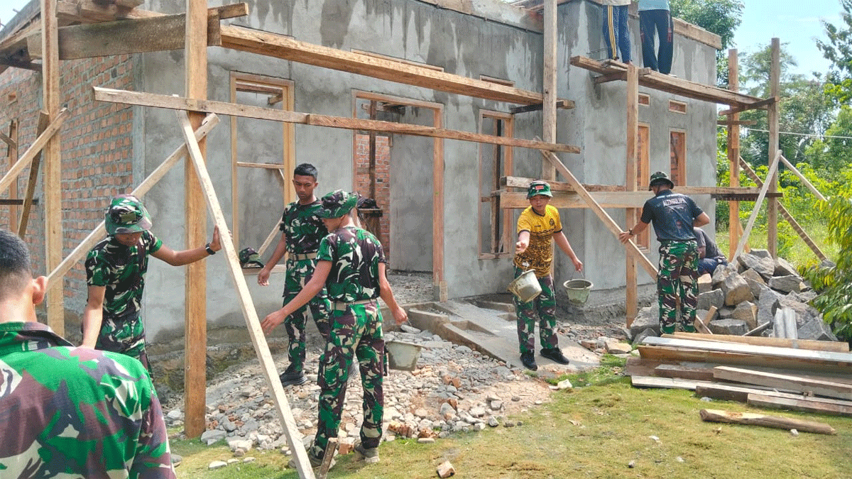 Personel TNI dan warga bahu membahu menyelesaikan rumah Parnen.