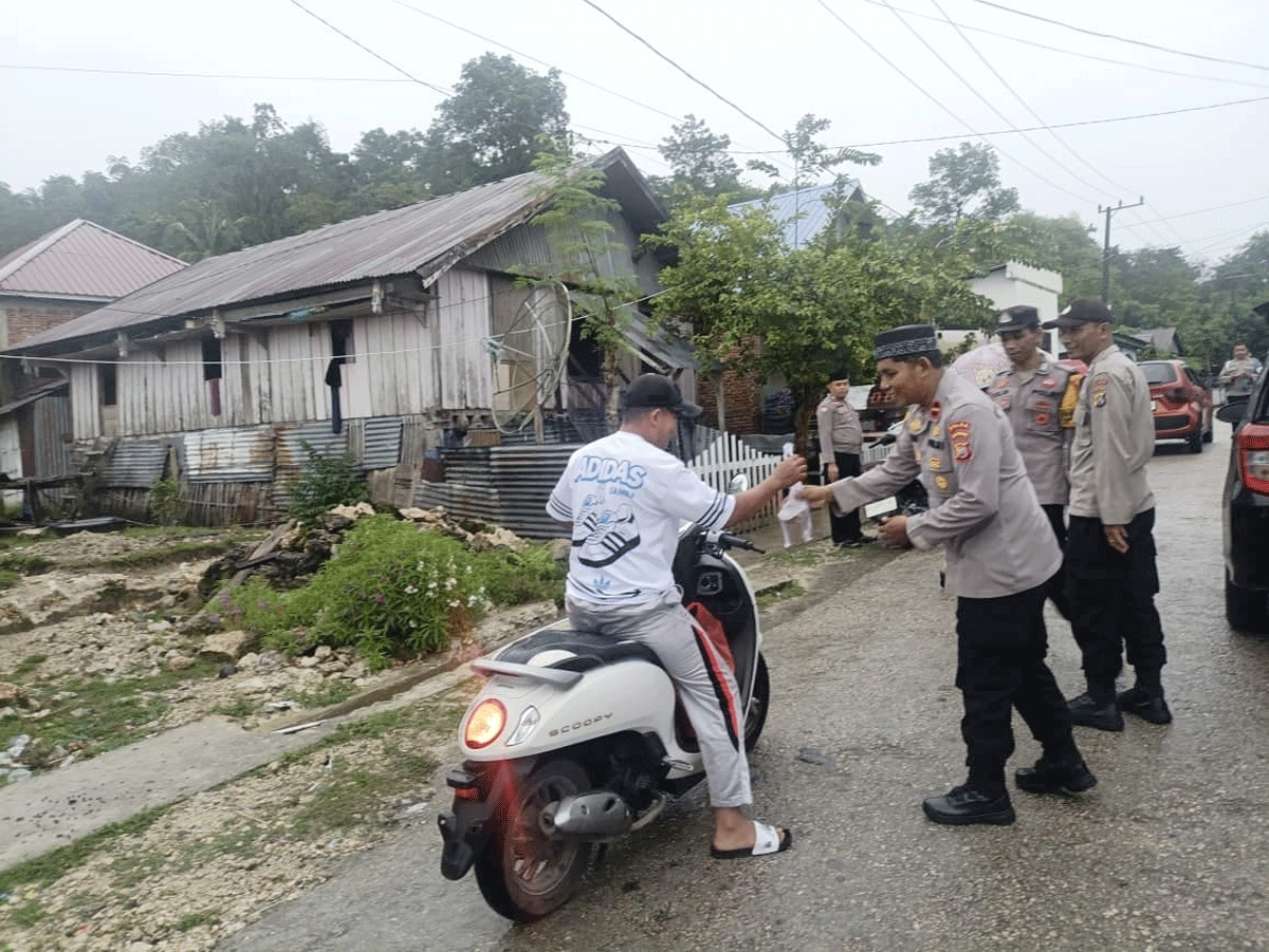 Kapolsek Sangia Wambulu Ipda Suharno, membagikan takjil kepada pengendara yang melintas di jalan raya.
