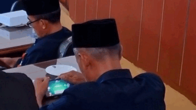 Camat Madiun, Muksin Harjoko yang tengah bermain game di rapat paripurna DPRD (Foto: Dok. Istimewa)