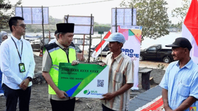 Bupati Muhammad Fawait serahkan secara simbolis kartu BPJS Ketenagakerjaan kepada nelayan pada program Pro Guse Update di kawasan Pantai Pancer, Desa Puger Kulon, Kecamatan Puger, Kabupaten Jember, Jawa Timur, Minggu (16/8/2026). (Foto: Tangkapan layar video)