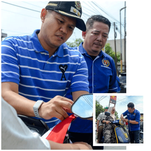 Wabup Bupati Serdang Bedagai Adlin Tambunan didampingi Ketua PWI Sergai Sugiono saat memasang bendera kepada salah satu pengendara sepeda motor