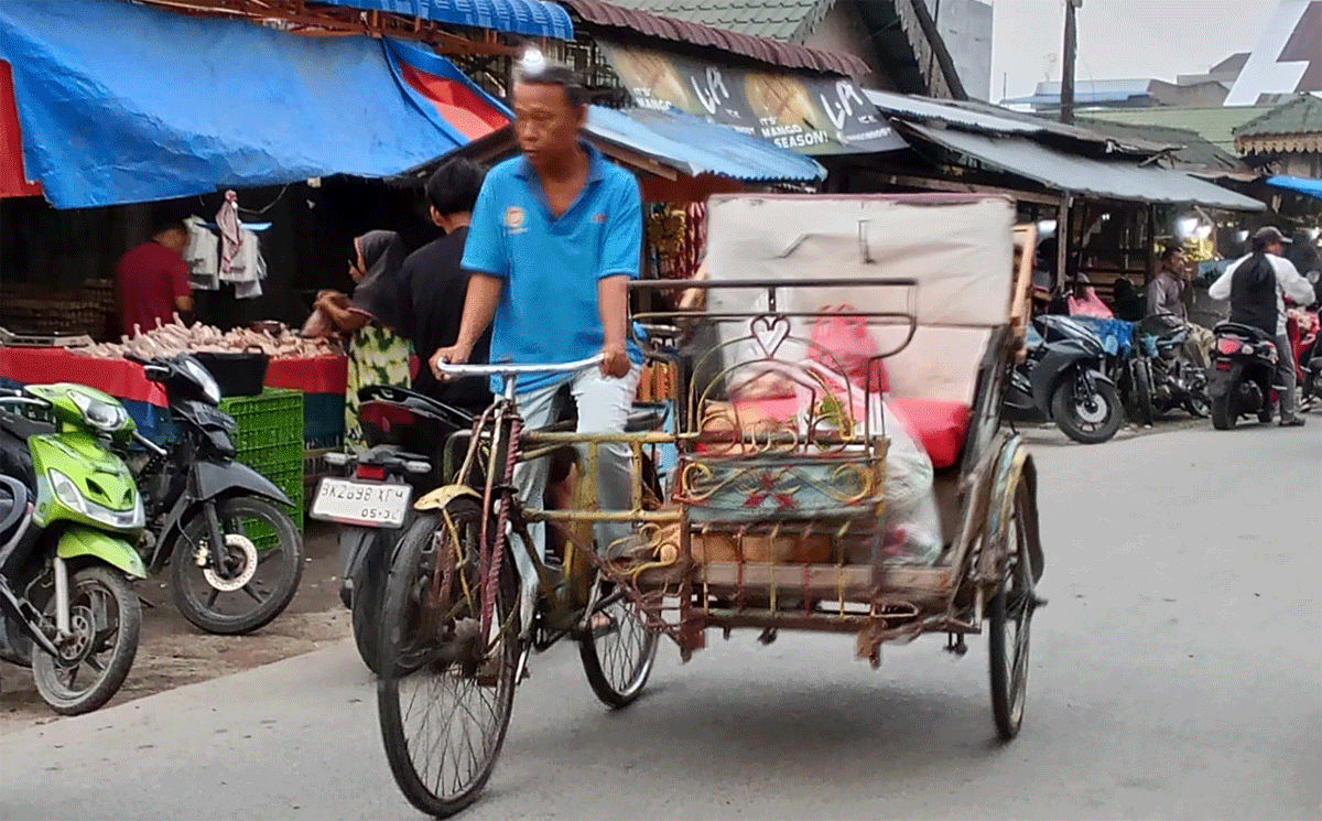 Tiga Abang Becak Dayung di Tanjung Beringin Tetap Bertahan Melayani Warga 1 M. Yusuf Abang becak dayung sedang mengantar barang dan Saiful Makruf saat mangkal di pajak tradisional Tanjung Beringin